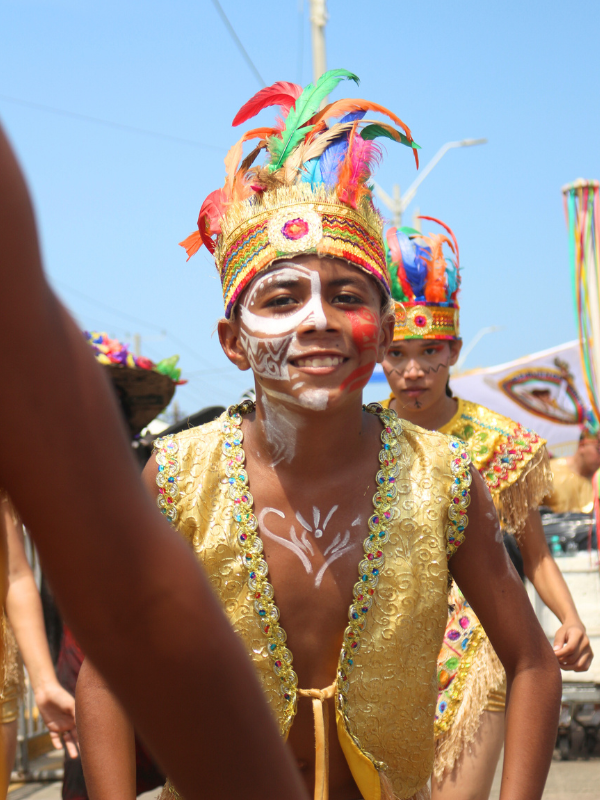 Crónica inmersiva sobre la Danza de Indios e Indias de Trenzas Chimila en el Carnaval de Barranquilla. A través de una experiencia en primera persona, Edu Lora Cueto narra su transformación de periodista a danzante durante la Gran Parada de Tradición en La Vía 40, explorando el origen ancestral de la trenza, su legado comunitario en el barrio Ciudadela 20 de Julio y la transmisión generacional que mantiene viva esta manifestación cultural con más de 90 años de historia. Un relato sobre identidad, resistencia, memoria y patrimonio vivo del Caribe colombiano.